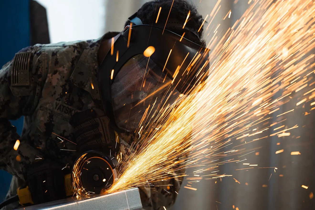 A Navy steelworker cuts a metal beam on a construction site (U.S. Navy photo by Seaman Jasmin L. Aquino)