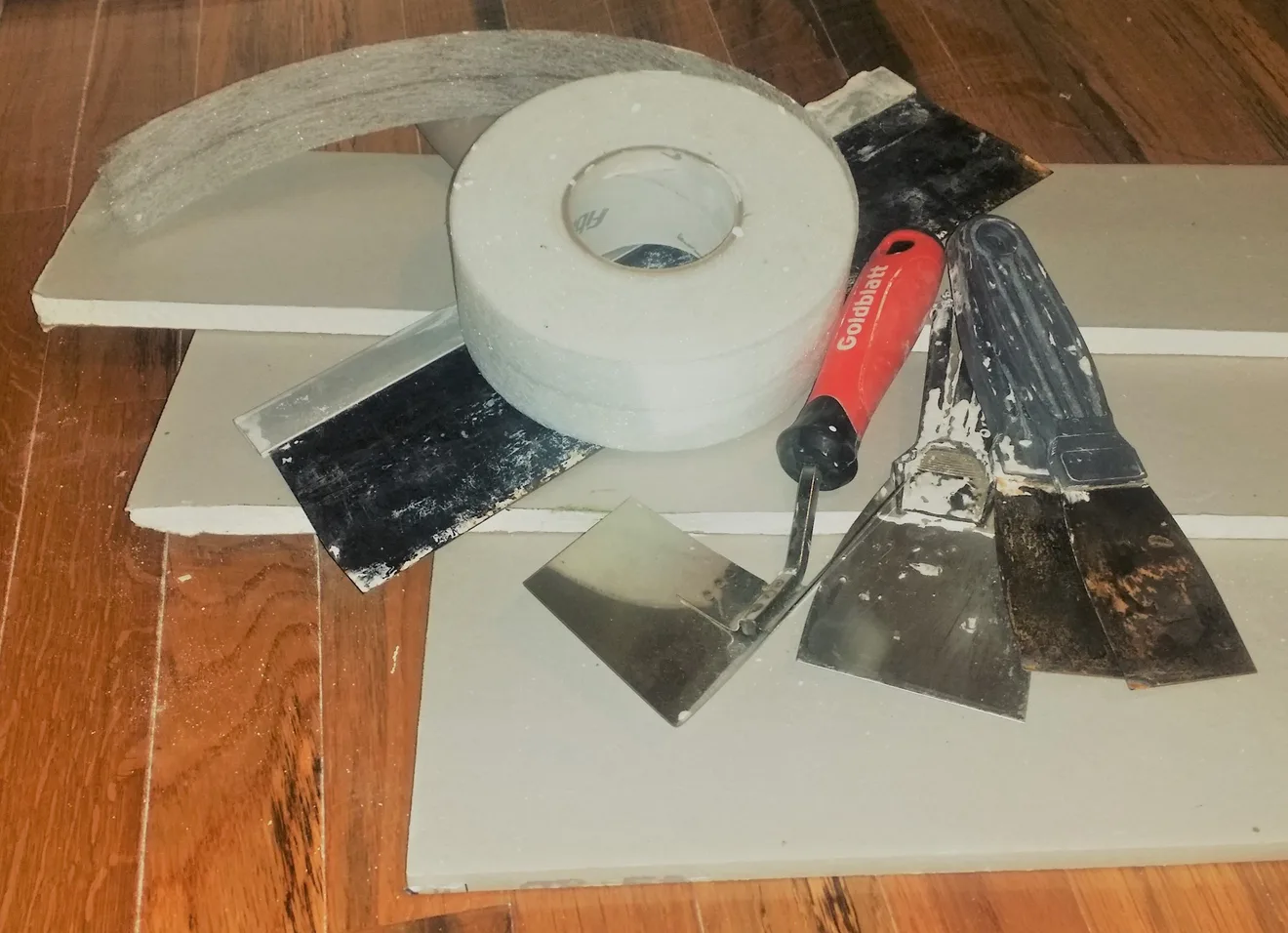Cut sheets of half-inch drywall with installation tools (Photo: Timothyjosephwood / Wikimedia Commons, CC BY-SA 4.0)