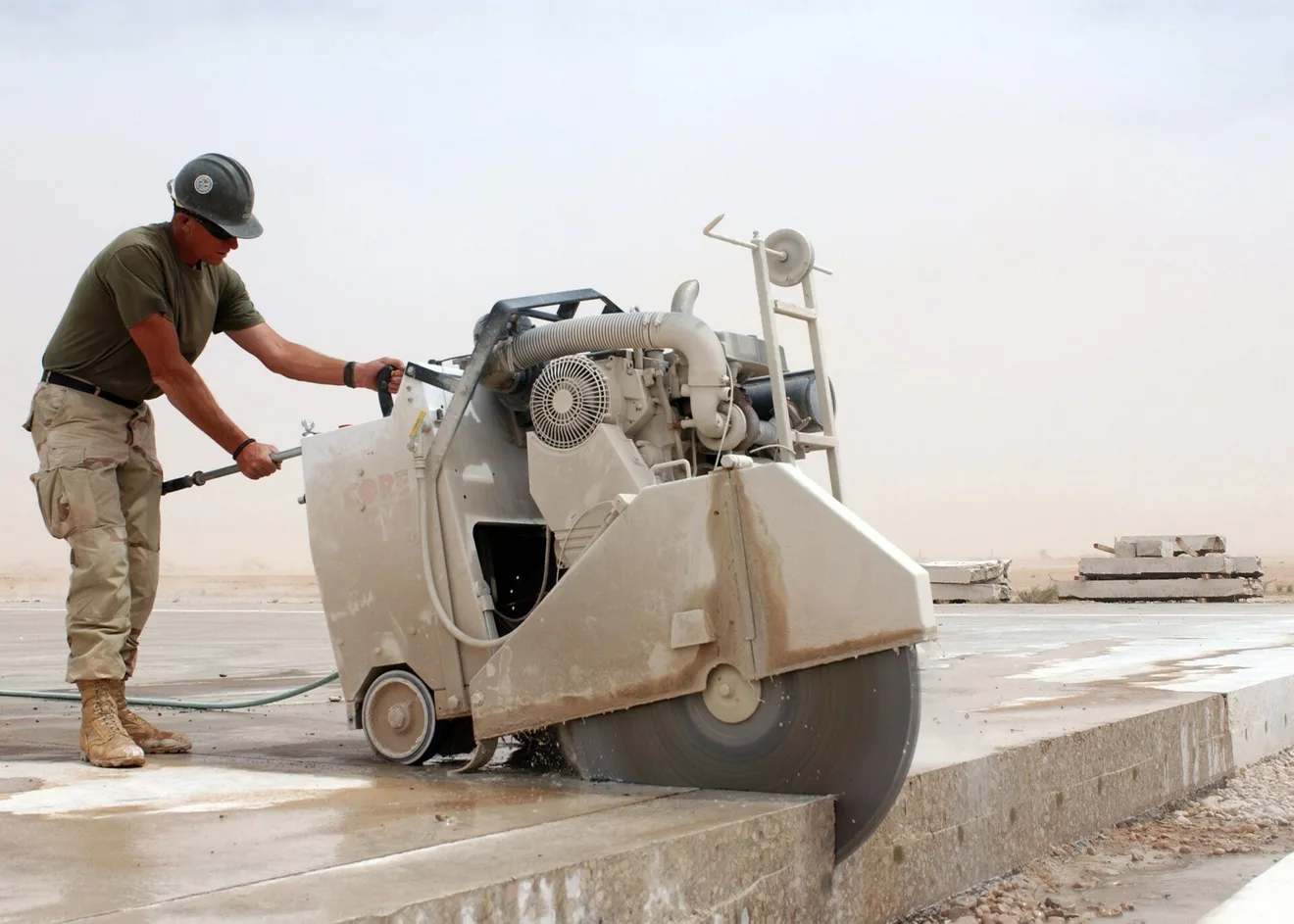 A Seabee cuts concrete with a diamond-blade concrete saw (U.S. Navy photo by Mark H. Overstreet)
