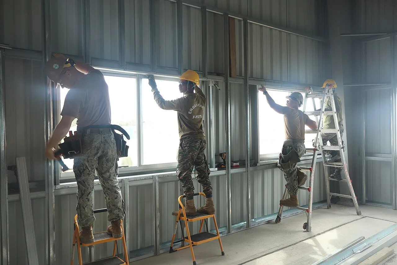 Crews installing metal wall framing studs (U.S. Navy photo by Matthew Noles)